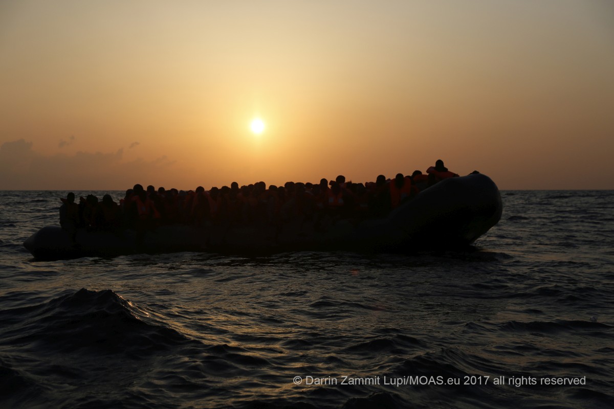 Migrants on board a rubber dinghy await rescue by the Malta-based NGO Migrant Offshore Aid Station (MOAS) in the central Mediterranean north of Sabratha on the Libyan coast