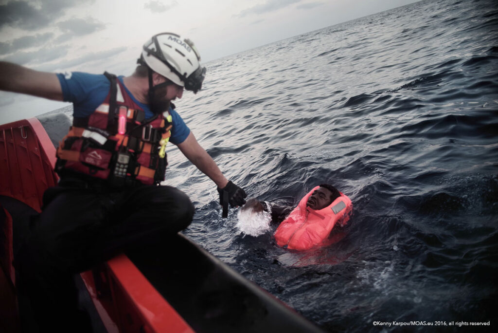 Just in time, a MOAS rescuer reaches a man who had fallen into the sea after falling from a packed boat.