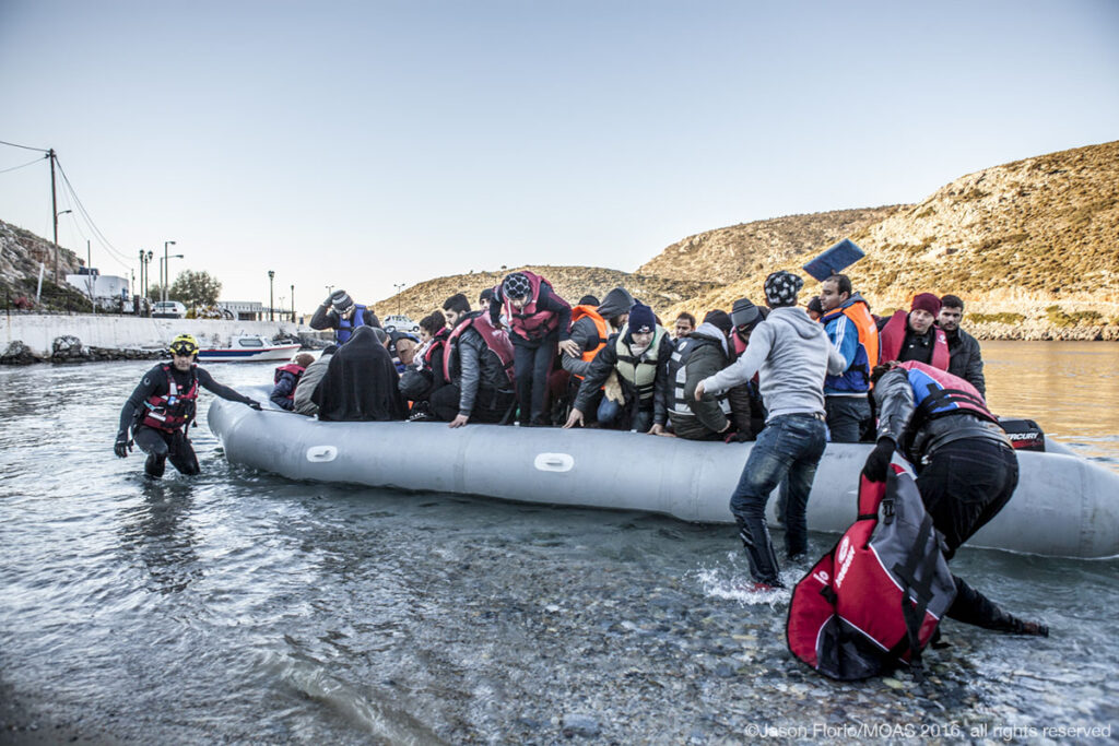 After reaching the Greek island of Agathonisi, migrants and refugees are helped onto the island.