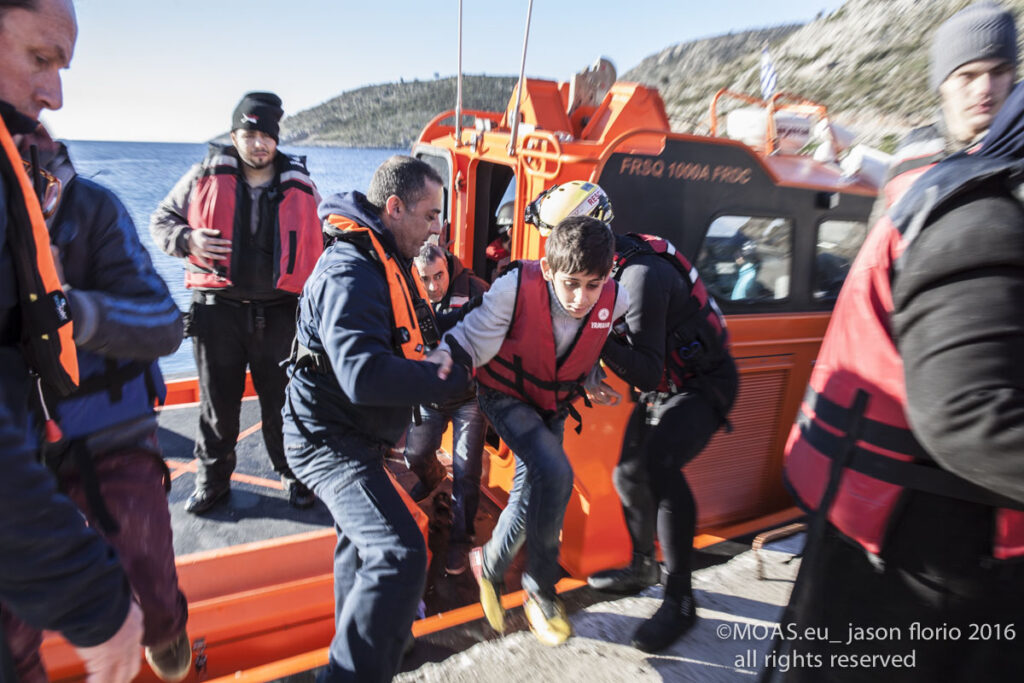 Refugees who had been attempting to cross the Aegean Sea are helped onto dry land by MOAS crew.